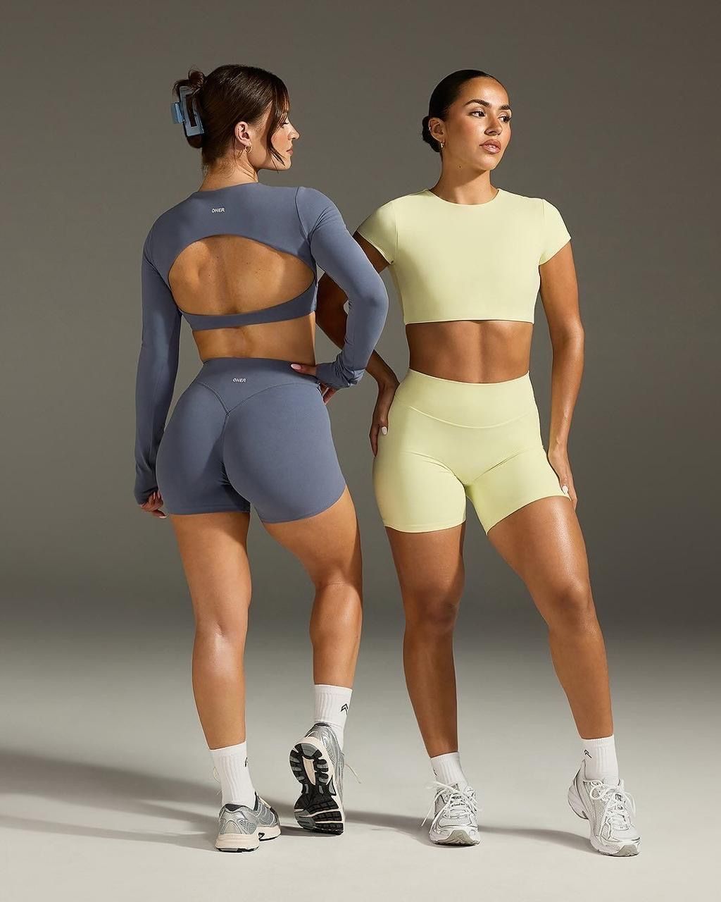 Two models of different heights and builds standing together